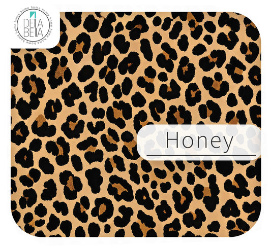 Close-up of Della Bella sticky back plastic in Honey leopard print. A light tan, beige, and black animal print peel and stick vinyl wrap for neutral maximalist furniture wrapping and door detail strips.