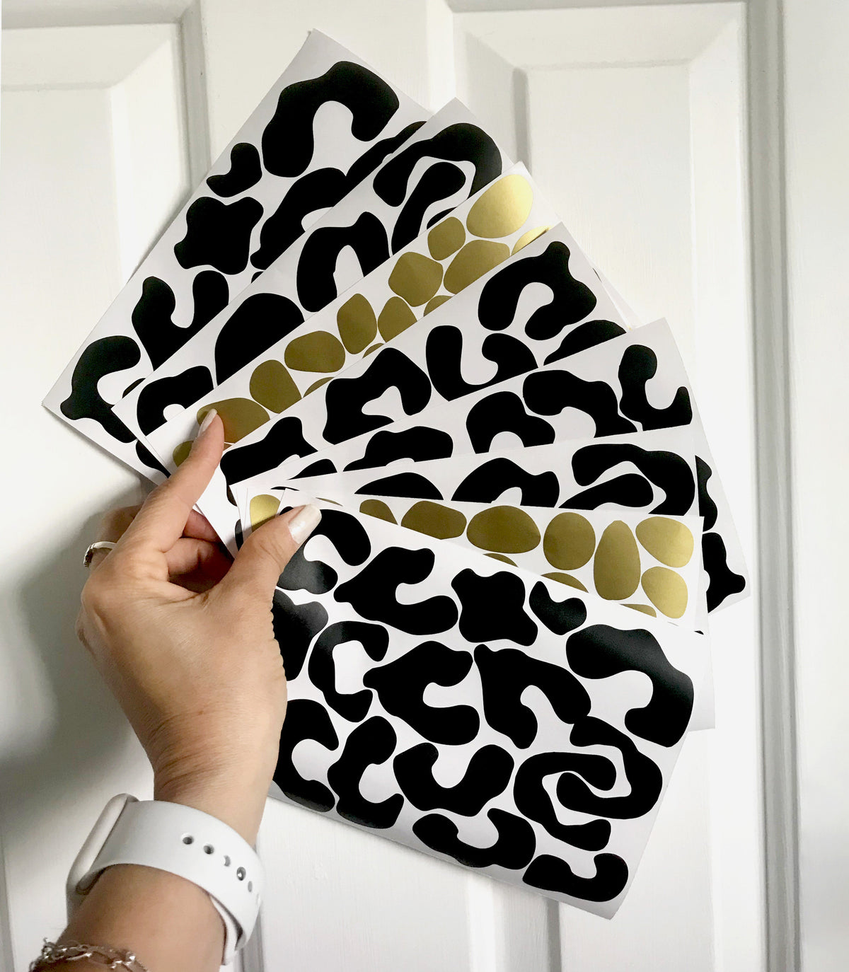 woman hand holding leopard wall stickers gold and black colours dots 