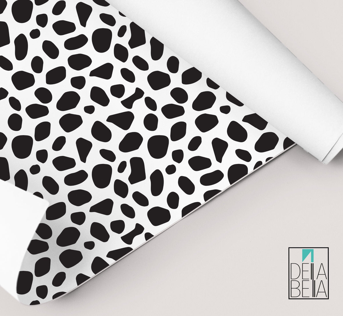 A rolled up piece of vinyl wrap with a dalmatian black spots pattern, partially unrolled to show the self-adhesive side.