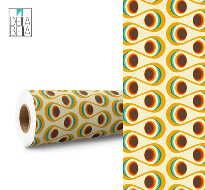 A roll of vinyl wrap with a retro eye pattern, featuring geometric shapes in yellow, black, and white colors.
